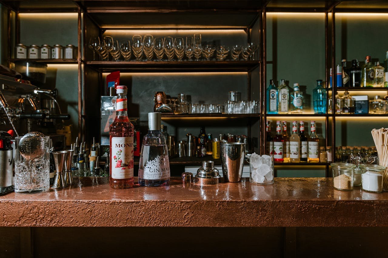 A stylish bar counter with spirits, cocktail tools, and glasses in Naples, Italy.
